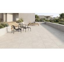 Großzügige moderne Terrasse mit hellen Terrassenplatten, schwarzen Metallsesseln, Beistelltisch, Holzliegen und bepflanzten Betonkübeln.