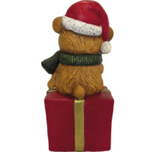 Weihnachtsfigur Teddybär mit Weihnachtsmütze und Schal sitzend auf einem Geschenkpaket, Rückansicht.
