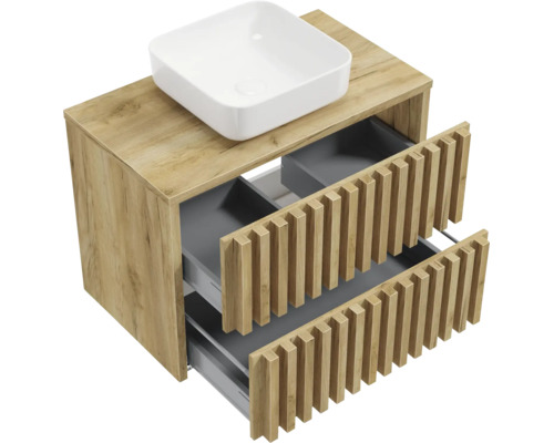 Waschtischunterschrank in Holzoptik mit Lamellenfront, zwei geöffneten Schubladen und weißem Aufsatzwaschbecken.