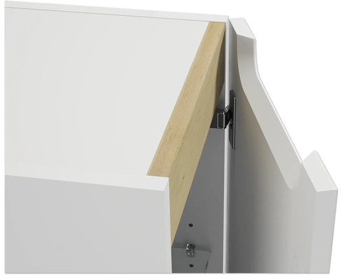Nahaufnahme eines weißen Schranks mit einem dekorativen Holzelement und einem Metallscharnier an der Tür.