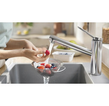 Einhand-Küchenarmatur in Chrom beim Waschen von Früchten in einem Sieb über der Spüle.