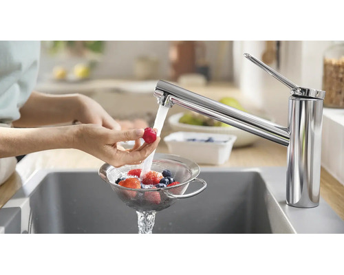 Einhand-Küchenarmatur in Chrom beim Waschen von Früchten in einem Sieb über der Spüle.