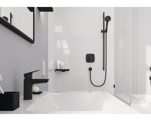 Modernes Badezimmer mit weißem Waschtisch, schwarzer Armatur und schwarzem Duschsystem auf weißen Fliesen.