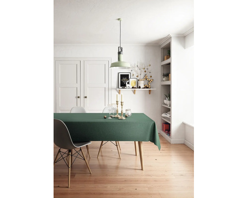 Helles Esszimmer mit grünem Tischtuch auf einem Holztisch, Eames-Stuhl, moderner Pendelleuchte und weihnachtlicher Wanddekoration auf einem Regal.