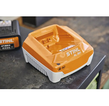 STIHL Schnellladegerät AL 301 mit Wartungs- und Ladestatusanzeige auf einer Arbeitsplatte.
