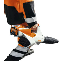 Stihl Akku-Laubblasgerät wird von einer Person in Arbeitskleidung getragen, Akku ist eingesetzt.