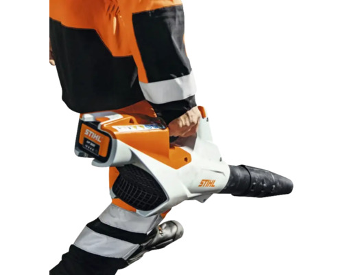 Stihl Akku-Laubblasgerät wird von einer Person in Arbeitskleidung getragen, Akku ist eingesetzt.
