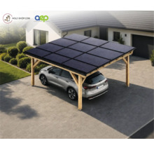 Holz-Solarcarport mit Photovoltaikmodulen auf dem Dach, unter dem ein Fahrzeug auf einer gepflasterten Auffahrt vor einem Wohnhaus parkt.