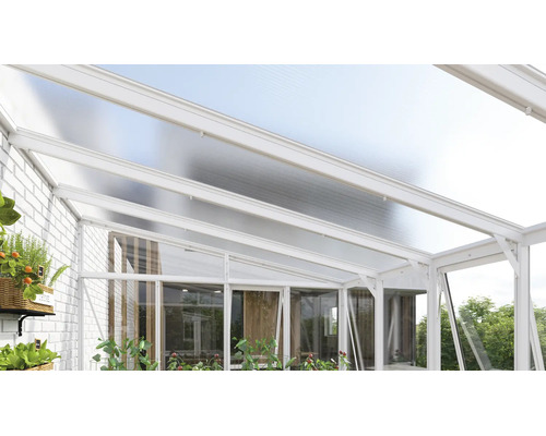 Moderne Terrassenüberdachung aus weißem Aluminium mit lichtdurchlässigem Dach und Glaswänden an einer weißen Ziegelwand.