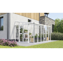 Anlehn-Gewächshaus aus Aluminium und Glas an einer Hauswand, mit Schiebetür und Dachfenster auf einer Terrasse mit Gartenpflanzen.