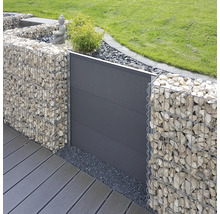 Modern gestaltete Gartenanlage mit Gabionen aus Metallkörben mit Steinfüllung und einem Sichtschutzelement aus Paneelen neben einer Terrasse.
