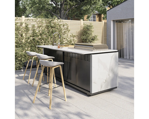 Moderne Außenküche mit Marmoroptik, Spüle, Grill und drei Barhockern auf einer hellen Terrasse vor einem Holzzaun.
