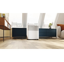 Mobiler Luftentfeuchter von Midea in einem hellen, modernen Dachgeschoss mit Holzboden und dunklen Sideboards.