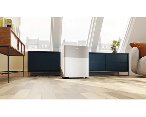 Mobiler Luftentfeuchter von Midea in einem hellen, modernen Dachgeschoss mit Holzboden und dunklen Sideboards.