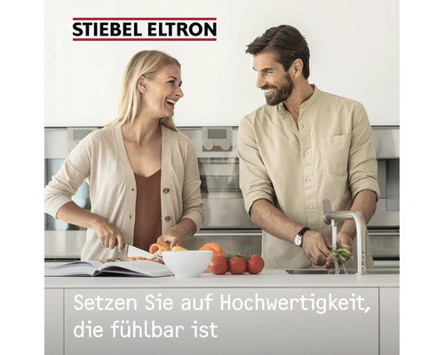"Stiebel Eltron Logo. Ein Paar bereitet in einer modernen Küche gemeinsam Essen zu
