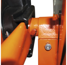 Nahaufnahme eines mechanischen Bauteils mit orangefarbenen Metallteilen, einer schwarzen Kunststoffabdeckung und einer Verschraubung.