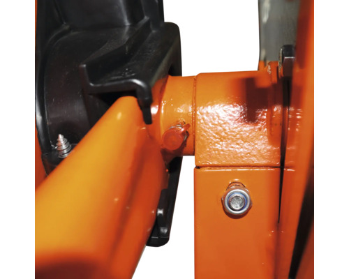 Nahaufnahme eines mechanischen Bauteils mit orangefarbenen Metallteilen, einer schwarzen Kunststoffabdeckung und einer Verschraubung.