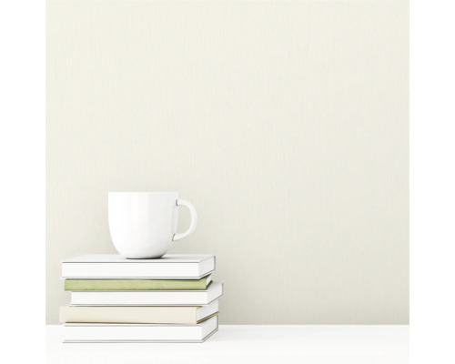 Strukturierte Tapete mit vertikalem Linienmuster. Im Vordergrund ein Stapel Bücher und eine Tasse.