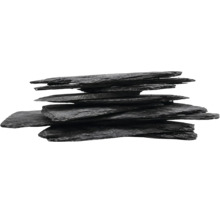 Stapel aus flachen, dunklen Natursteinplatten mit bruchrauen Kanten.