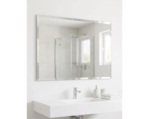 Rechteckiger Wandspiegel mit Facettenschliff über einem modernen weißen Waschbecken in einem hellen Badezimmer.