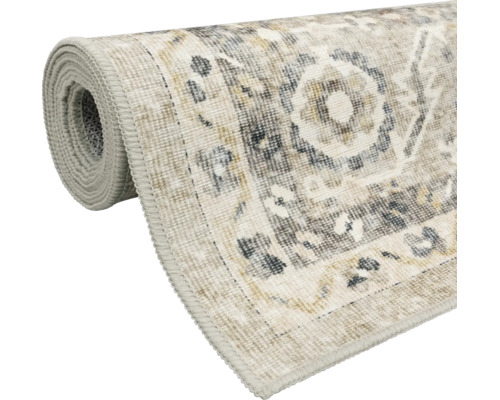Gerollter Teppich mit Vintage-Muster in Beige und Grau, gewebte Oberfläche mit Kettelrand.