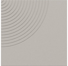 Quadratische graue Fliese mit strukturiertem geometrischem Muster aus konzentrischen Kreisrillen in einer Ecke.