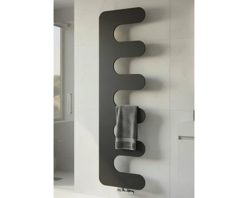 Moderner Design-Heizkörper in Anthrazit mit geschwungenen Lamellen, wandmontiert im Badezimmer, mit grauem Handtuch.