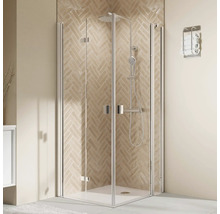 Eckduschkabine mit Falttüren und Duschsystem vor einer Wand mit Fischgrätenfliesen in einem modern eingerichteten Badezimmer.