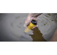Eine Hand hält einen gelben, wasserdichten Pinpointer-Metalldetektor unter Wasser.