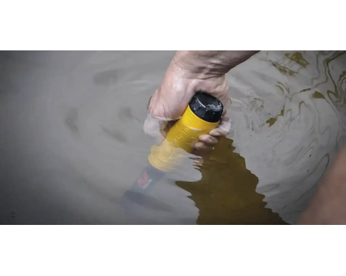 Eine Hand hält einen gelben, wasserdichten Pinpointer-Metalldetektor unter Wasser.