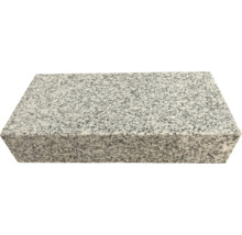 Blockstufe aus Granit mit gesprenkelter Oberfläche.