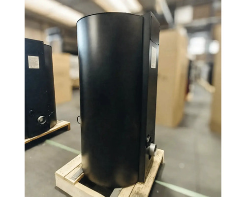 Schwarzer Kaminofen aus Metall auf einer Holzpalette.
