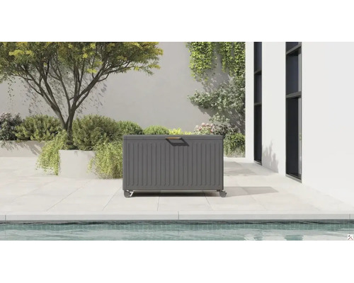 Moderne Garten-Auflagenbox aus Metall mit Rollen und Holzgriff auf einer hellen Terrasse am Pool.