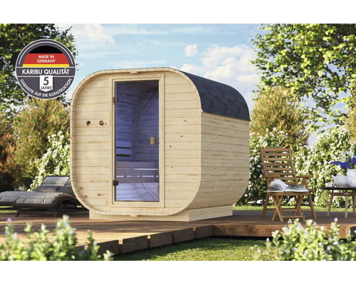 Gartensauna aus Holz mit ovaler Form und Glaseingangstür auf einer Holzterrasse im Garten inklusive Karibu Qualitäts- und Garantie-Siegel.