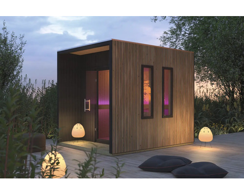 Moderne Garten-Sauna mit vertikaler Holzlamellen-Fassade und zwei schmalen Fenstern auf einer Holzterrasse im Außenbereich.