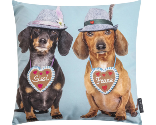 Zierkissen mit einem Aufdruck von zwei Dackeln namens Sissi und Franz, die Trachtenhüte und Lebkuchenherzen tragen.