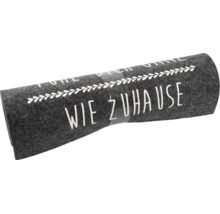 Zusammengerollter grauer Filzläufer mit weißem Schriftzug Fühl dich wie zuhause und Blätterdekor.