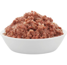 Eine weiße Schüssel gefüllt mit Nassfutter für Haustiere, bestehend aus zerkleinertem Fleisch.