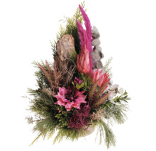 Herbstliches Gesteck mit Protea, Heidekraut, Tannengrün und einem Stück Baumrinde als dekorativer Blickfang.