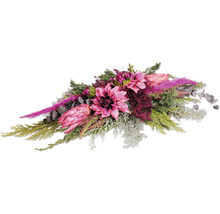 Künstliches Blumenarrangement mit Dahlien und Proteen sowie verschiedenen Grünpflanzen und Zweigen als dekorativer Tischschmuck