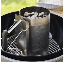 Weber Anzündkamin aus Edelstahl mit Griff in einem Kugelgrill auf dem Grillrost platziert für Holzkohle und Briketts.