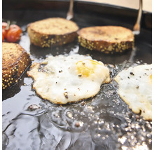 Spiegeleier und Brot werden zusammen in einer gusseisernen Grillpfanne zubereitet.