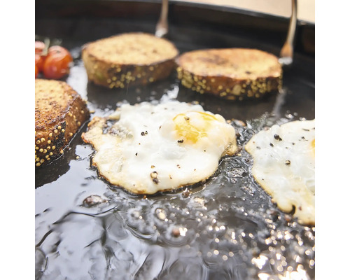 Spiegeleier und Brot werden zusammen in einer gusseisernen Grillpfanne zubereitet.
