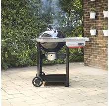 Weber Performer Holzkohlegrill mit Arbeitstisch auf einer Terrasse stehend.