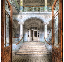 Innenansicht eines verlassenen Gebäudes mit Treppe und offenen Türen