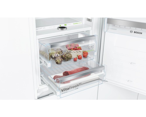 Innenansicht eines Kühlschranks mit VitaFresh Schubladen für die Lagerung von Lebensmitteln. Im oberen Fach befinden sich Artischocken und Erdbeeren und im unteren Fach Fleisch. Bosch Logo.