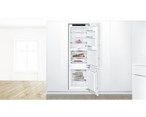 Geöffneter Einbaukühlschrank mit Gefrierfach in einer hellen Küche mit Lebensmitteln