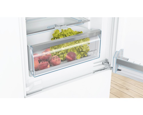 Innenansicht eines Kühlschranks mit VitaFresh Schublade, gefüllt mit Salat und Pfirsichen