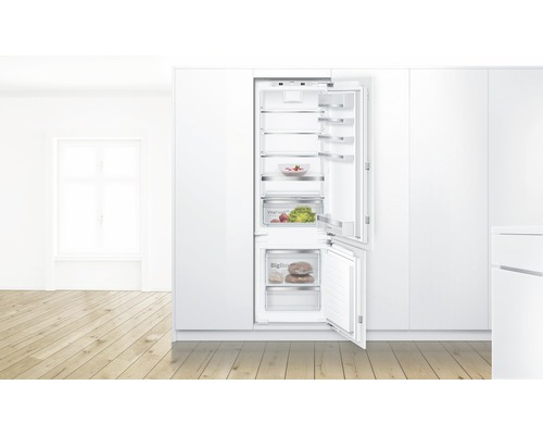 Einbaukühlschrank mit offener Tür und verschiedenen Lebensmitteln im Inneren.