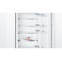 Innenraum eines Kühlschranks mit Glasablagen und einer Schüssel mit Erdbeeren